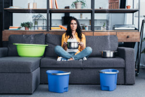 Beautiful woman with pots and buckets dealing with damage restoration in north hills