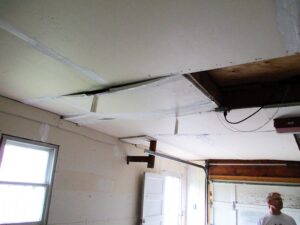 Man in glasses surveys damage to inside of home thinking about damage restoration in north hills